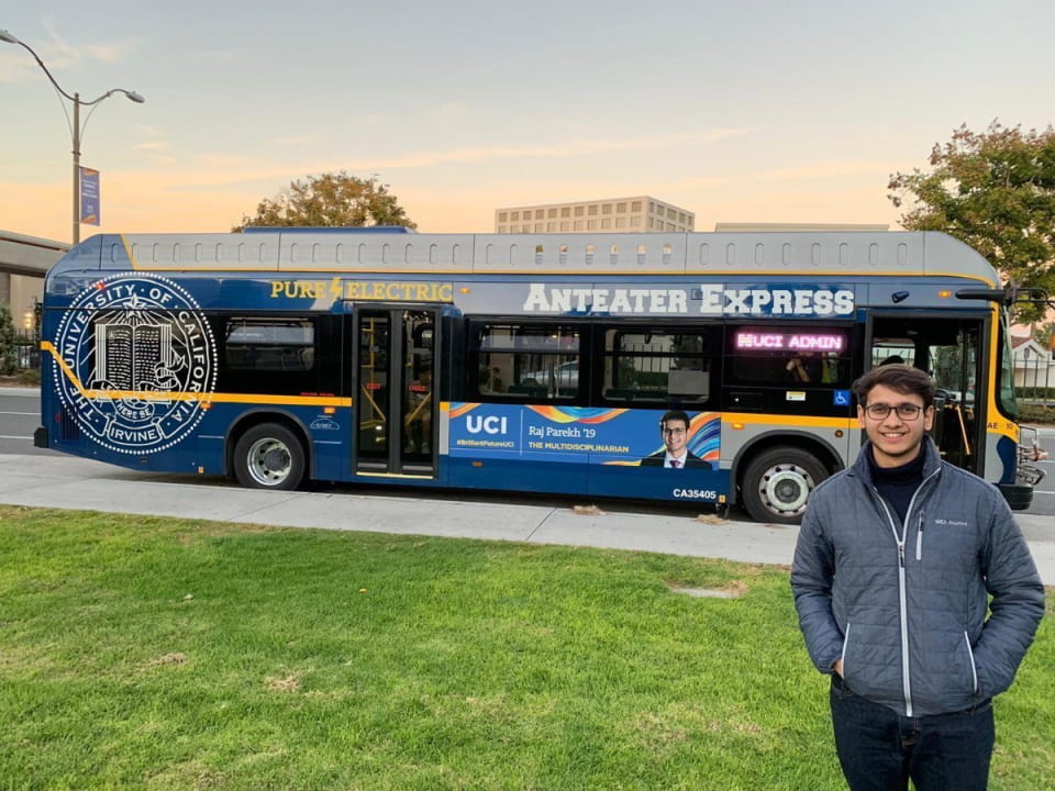 UCI student Raj poses in front of bus